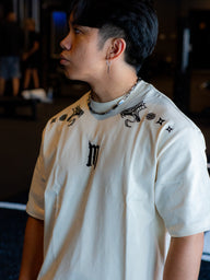 Collar and shoulder detail on the Kenshin Premium oversized tee in pastel cream, worn