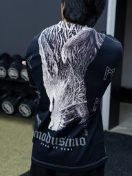 Close-up of the Fenrir white wolf back print and Modusimo logo on the black Premium tee, worn