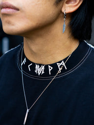 Collar detail with rune neck print on the Fenrir Premium oversized tee in black, worn