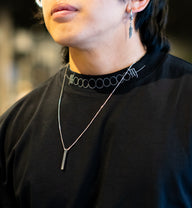 Collar detail with chain on the Strength and Power Premium oversized tee in black, worn