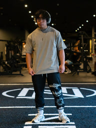Model wearing the Death Whistle Premium oversized tee in snakestone beige, front view