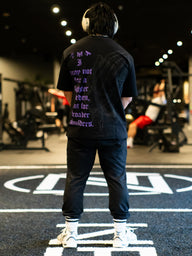 Model from behind wearing the Strength and Power Premium oversized tee in black