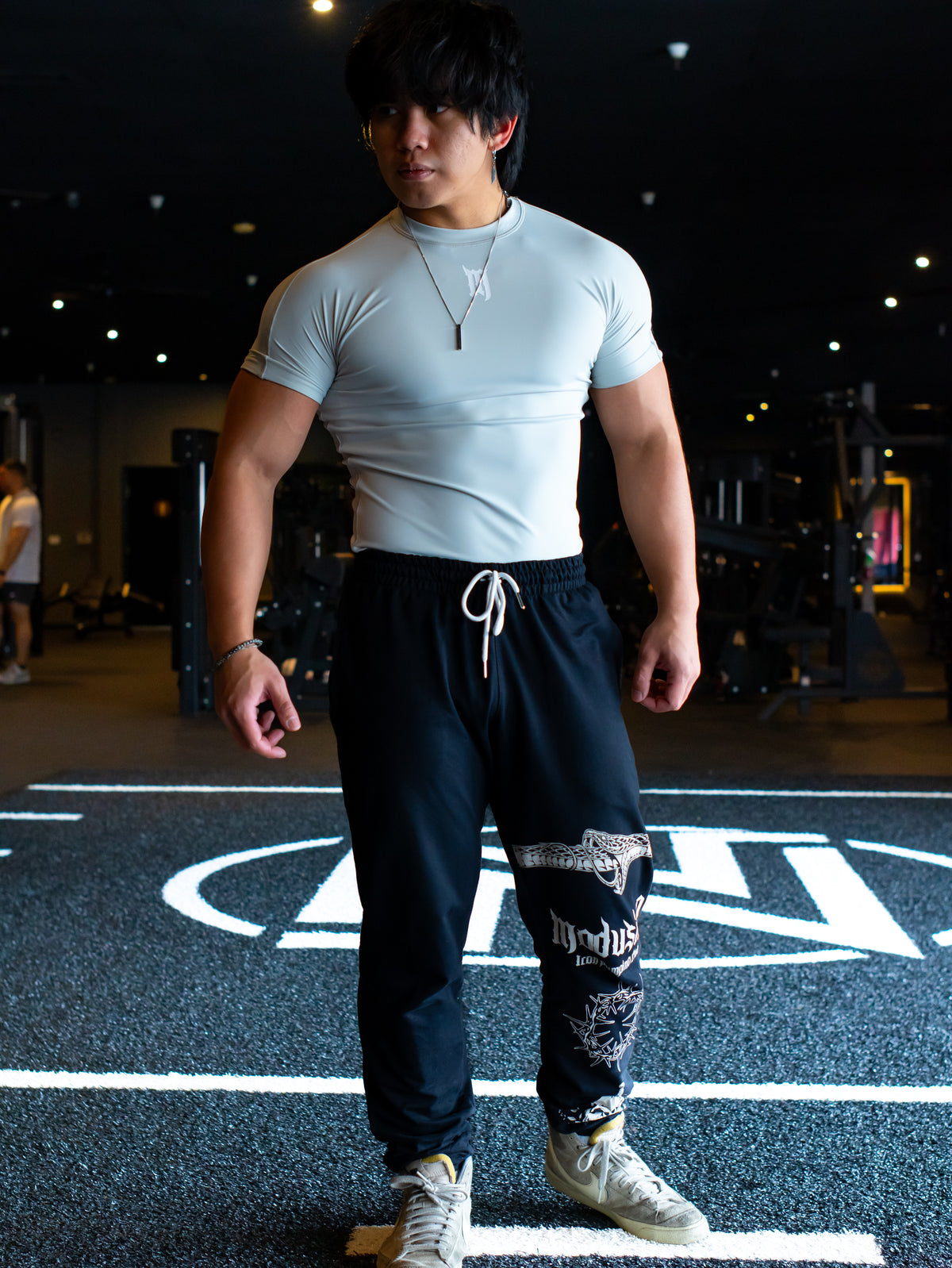 Model wearing the Endless compression tee in quicksilver gray with black joggers, front view — second view