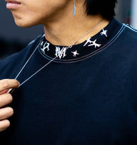 Collar detail with rune neck print on the Gatekeeper Premium oversized tee in black, worn