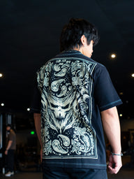Close-up of the Strength Within cream ornamental back print on the black Premium tee, worn