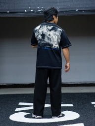 Model from behind wearing the Gatekeeper Premium oversized tee in black, in the gym