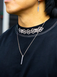 Collar detail with chain and neck logo on the Sacrifice Premium oversized tee in black, worn