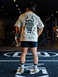 Model from behind wearing the Kenshin Premium oversized tee in pastel cream with oni mask print