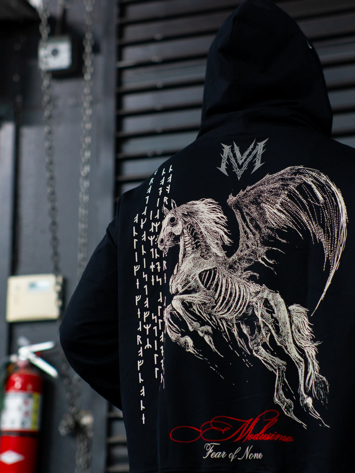 Close-up of the Into Battle warrior back print on the black stringed hoodie, worn — second view