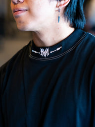 Collar detail with neck logo on the Fear of None Premium oversized tee in black, worn