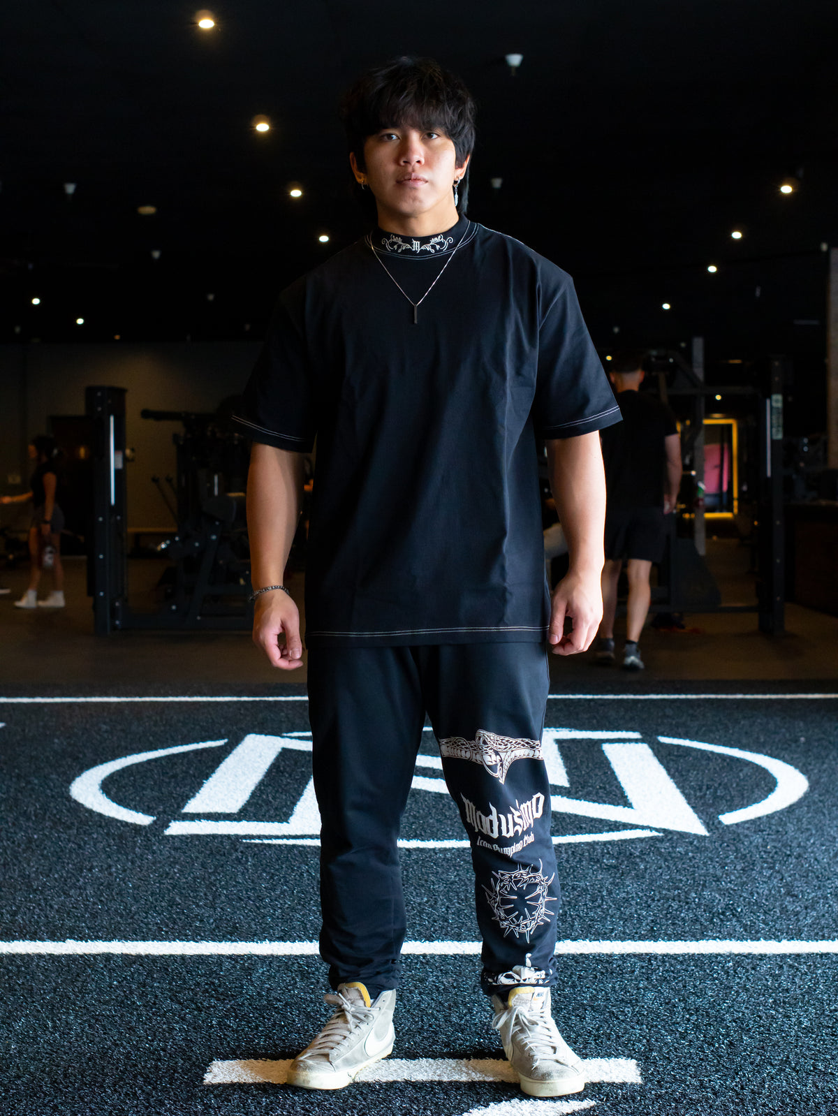 Model wearing the Strength Within Premium oversized tee in black with printed pants, front view — second view