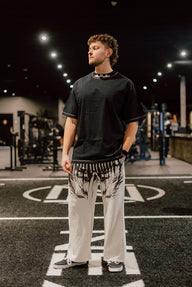 Model wearing the Ashes to Ashes Premium oversized tee in black with cream pants, front view