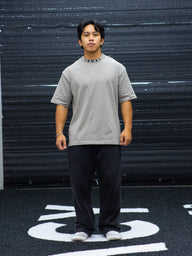Model wearing the Chase the Night Premium oversized tee in snakestone with black pants, front view