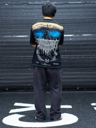 Model from behind wearing the Ragnarok Premium oversized tee in black, in the gym