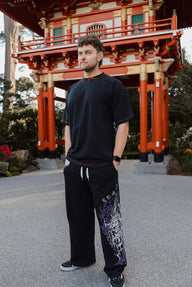Model wearing the Ablaze Premium oversized tee in black with printed sweatpants, front view