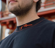 Collar detail with neck logo on the Ablaze Premium oversized tee in black, worn