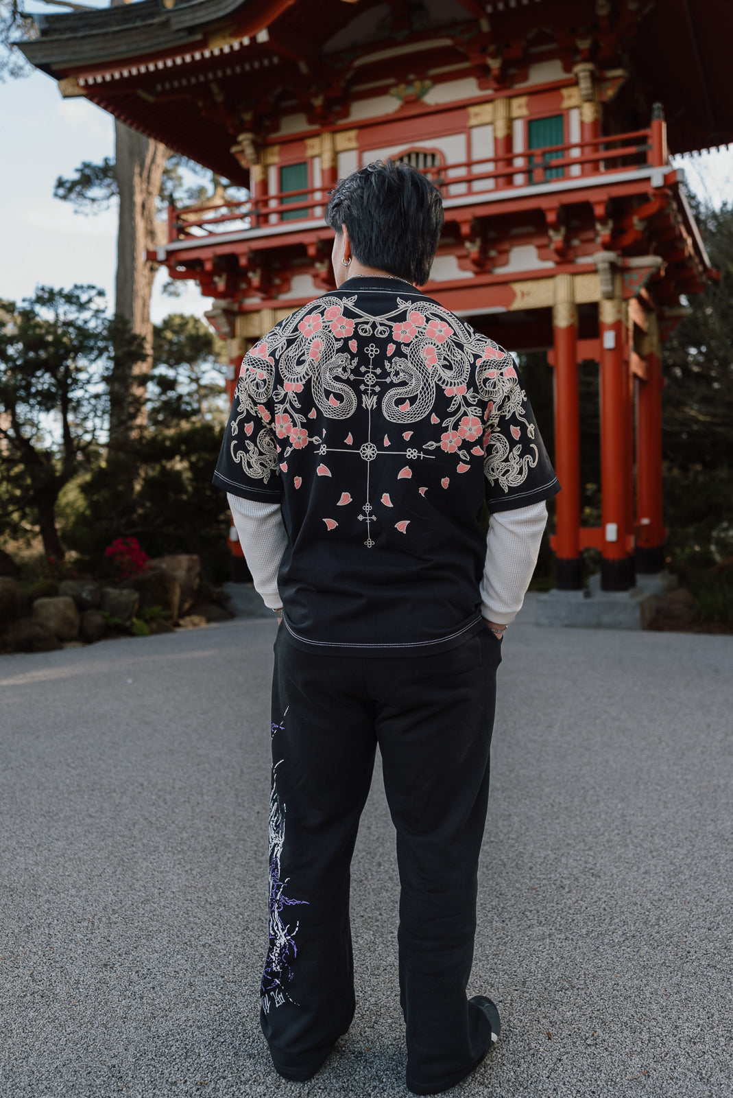 Model from behind wearing the Hollow Soul Premium oversized tee in black at a red shrine gate — second view