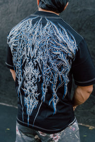 Back of the Onigami Premium oversized tee in black with icy blue demon mask print, worn by model