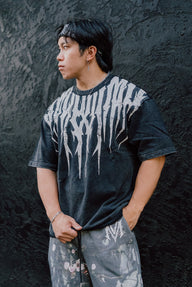 Model in the Sigil comfort shirt in moon wash black, three-quarter view with printed pants
