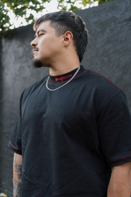 Model in the Let's Rock! Premium oversized tee in black, side profile with red contrast stitching