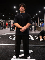 Model wearing the Royal Flush Premium oversized tee in black with black pants, front view