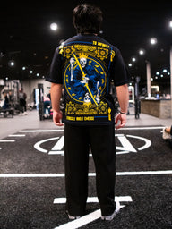 Model from behind wearing the Royal Flush Premium oversized tee in black, in the gym