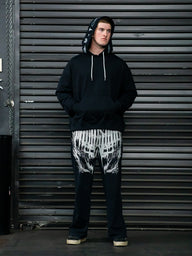 Model wearing the Into Battle stringed hoodie in black with printed pants, full length front view