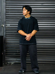Model wearing the Warmonger Premium oversized tee in black with black pants, front view